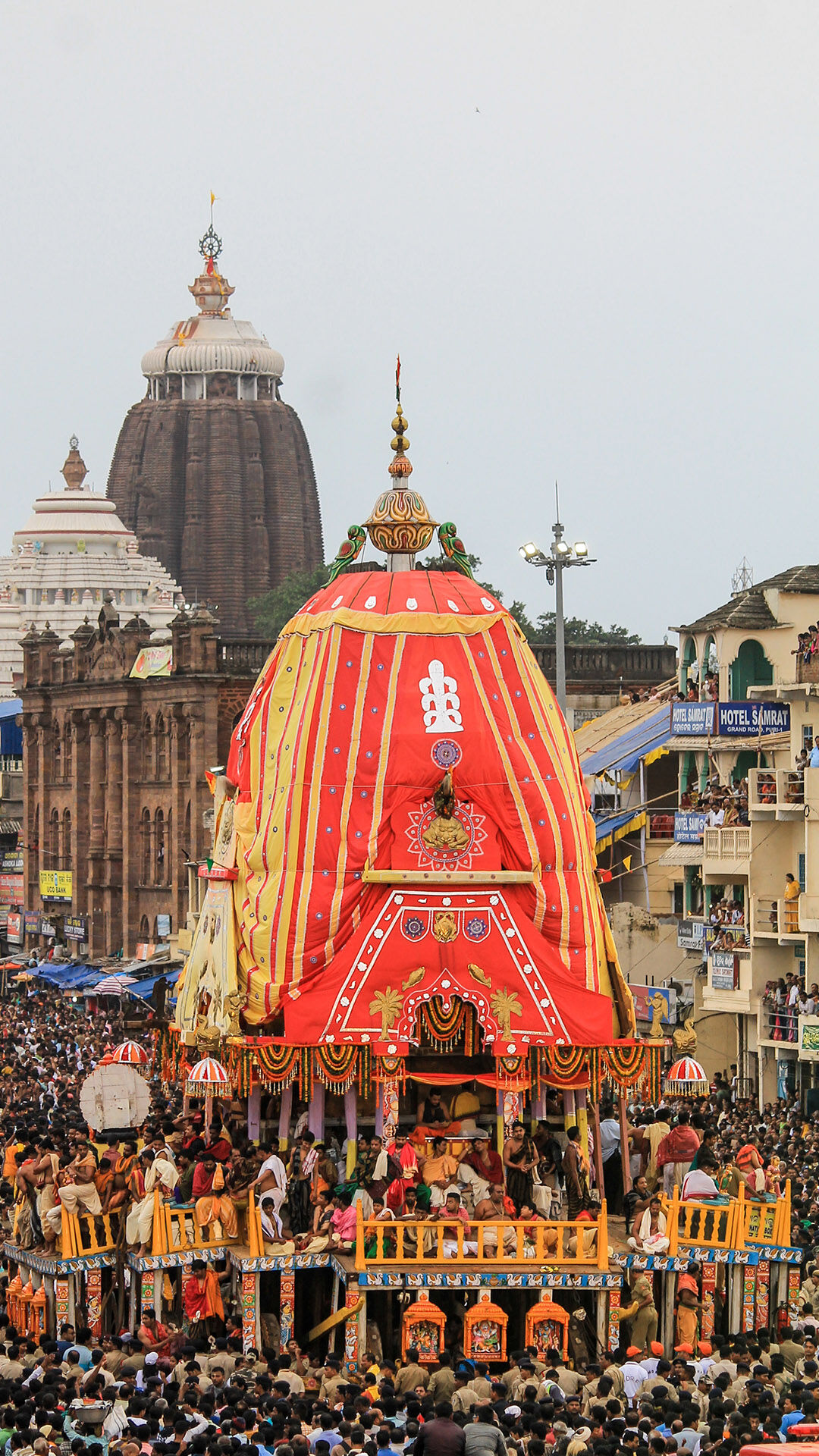 Rath Yatra procession in Puri with Lord Jagannath’s decorated chariot surrounded by devotees and the Jagannath Temple in the background.